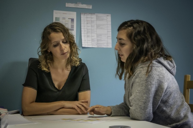 Deux femmes travaillant, assises autour d'une table.