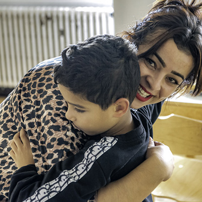 Portrait d'une jeune femme et un enfant se prenant dans les bras.