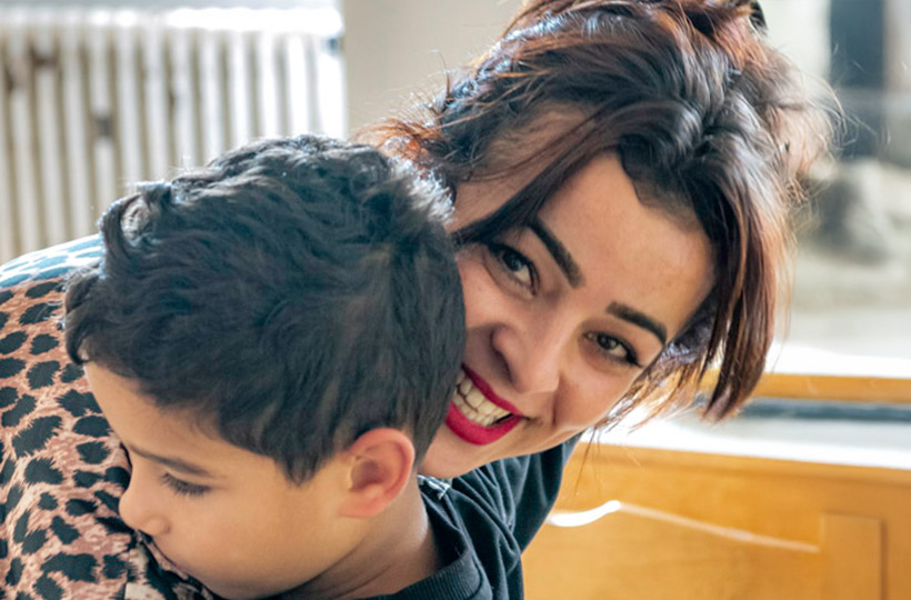 Portrait d'une jeune femme et un enfant se prenant dans les bras.