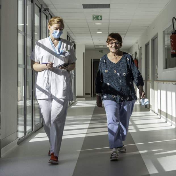 Deux femmes marchant dans un couloir d'hôpital.